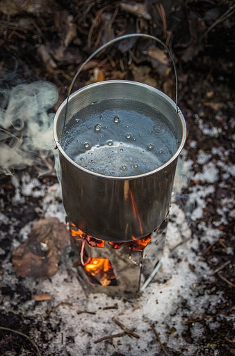 Hiking bowler with water, boiling on a hiking stove, a campfire