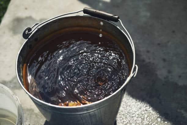 Close-up of a filled iron bucket of clean water from a well.