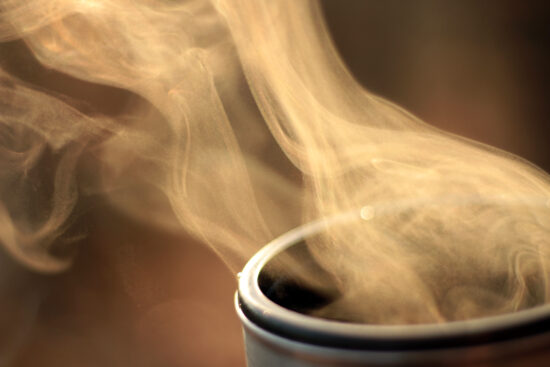 Steam of hot tea in a close-up against the sunlight; Copy space; Shallow depth of field