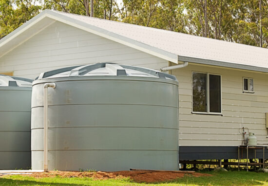 Australian building rainwater conservation tanks for water supply on new house in rural region